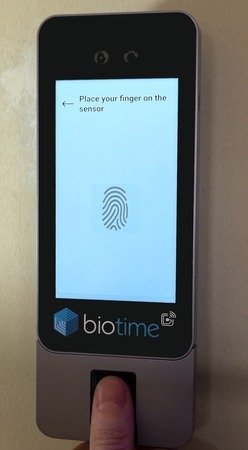 An employee placing their finger on the bt505's fingerprint sensor.